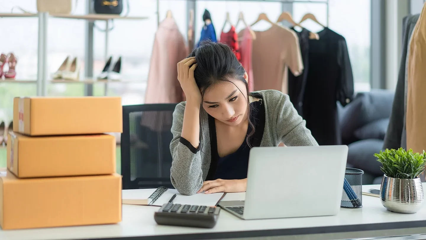 Small business owner looking at website analytics on laptop, confused by low traffic